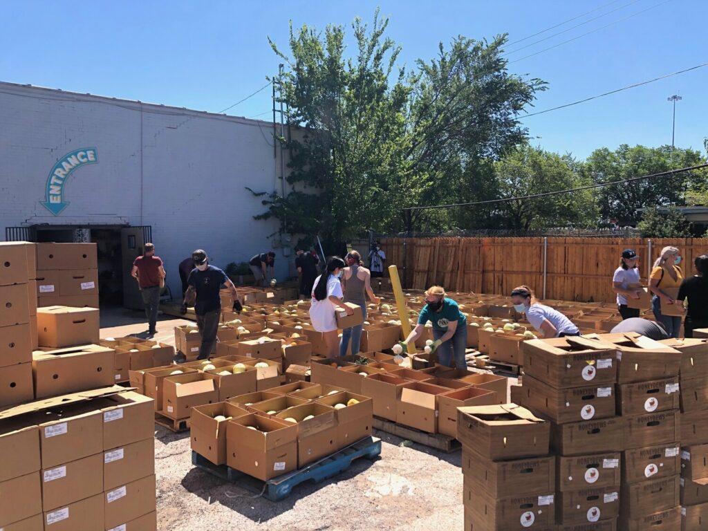Volunteers prepare crates of food in preparation for a giveaway. Manpower is a limited resource, but it’s a critical part of the coalition’s ability to provide food.