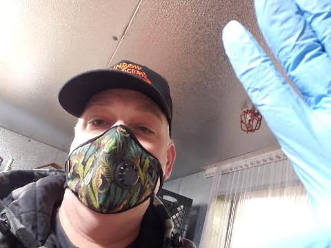 Gordon, wearing a mask and latex gloves.