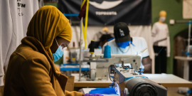 Woman sewing Top Manta clothing.